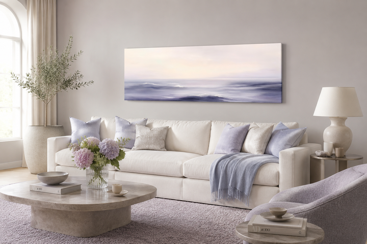 Purple Ocean Waves long horizontal coastal canvas wall art above a white sofa in a living room.