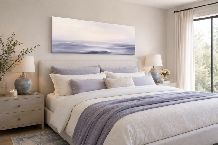 Long horizontal canvas art of purple ocean waves hanging above a bed in a serene bedroom.