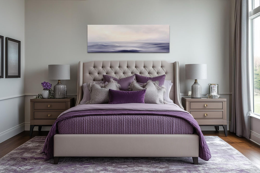 Purple Ocean Waves long horizontal coastal canvas wall art hanging above a tufted bed.