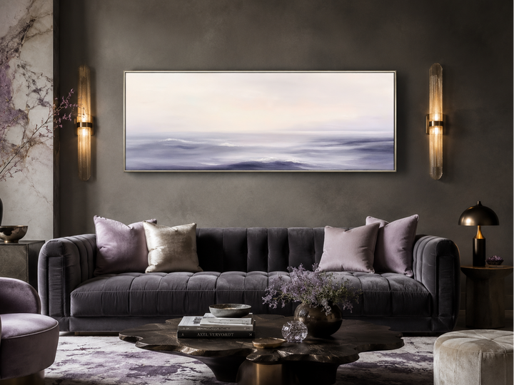 Purple Ocean Waves long horizontal coastal canvas wall art hanging above a modern tufted sofa.