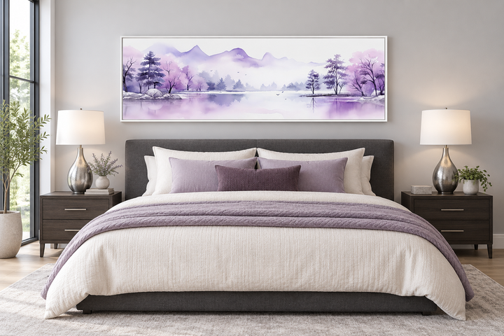 Purple mountains lake horizontal watercolor wall art in a white frame above a bed.