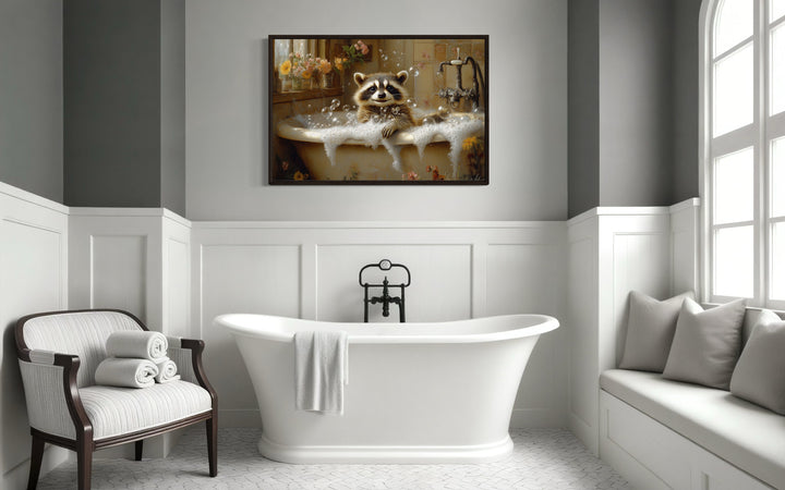 Raccoon in a bubble bath rustic framed canvas wall art hanging above a white freestanding bathtub.