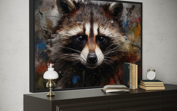 Framed canvas wall art featuring a raccoon portrait in a modern pop art style with paint splatters.