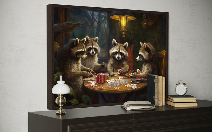 Raccoons Playing Poker Framed Canvas Wall Art displayed on a dark wood dresser in a room.
