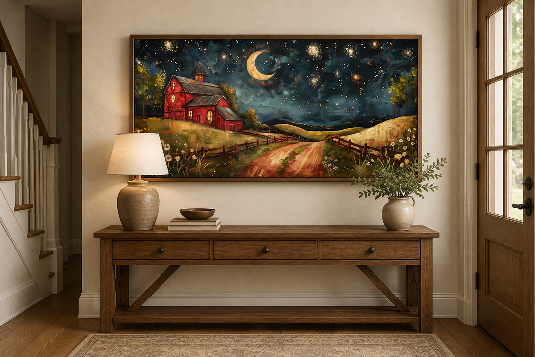 Framed wall art of a red barn under a starry night sky with a crescent moon above a wooden console.