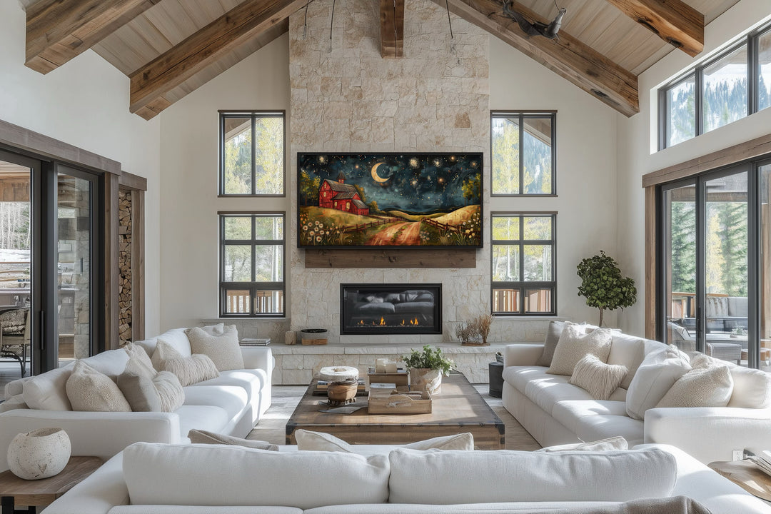 Red barn wall art under a crescent moon and stars displayed above a fireplace in a rustic living room