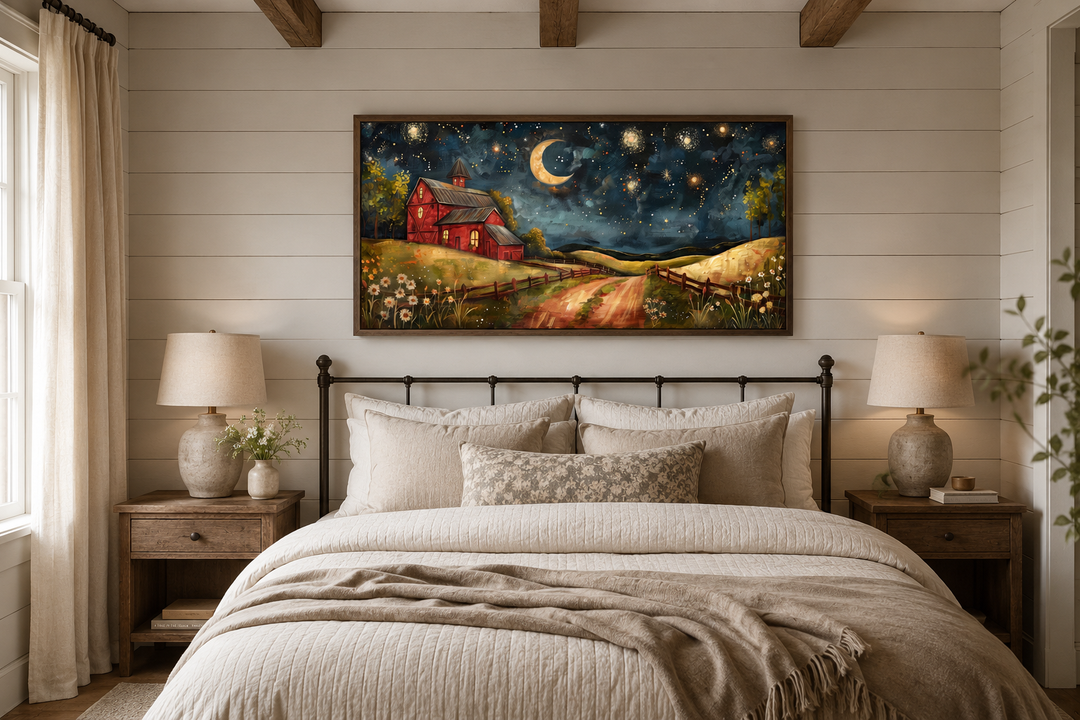 Framed wall art of a red barn under a starry night sky with a crescent moon above a cozy bed.