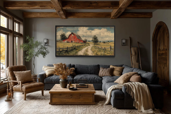 Large horizontal canvas print of a rustic red barn landscape in a farmhouse living room.