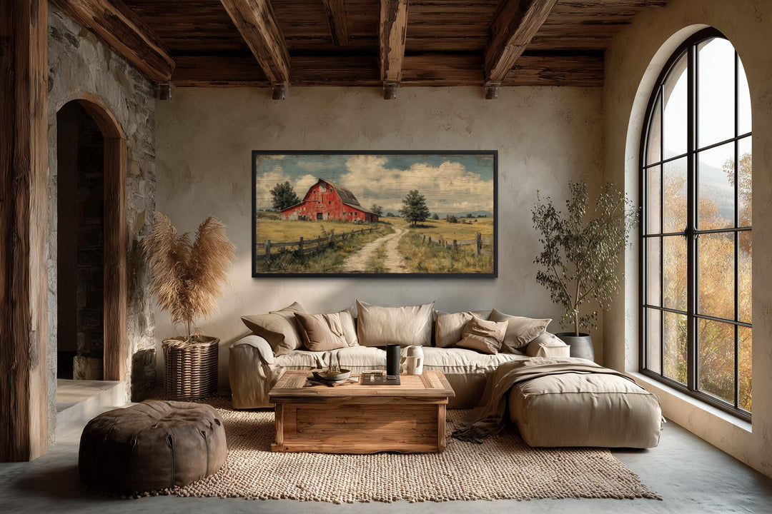 Large horizontal canvas print of a red barn landscape in a rustic farmhouse living room.