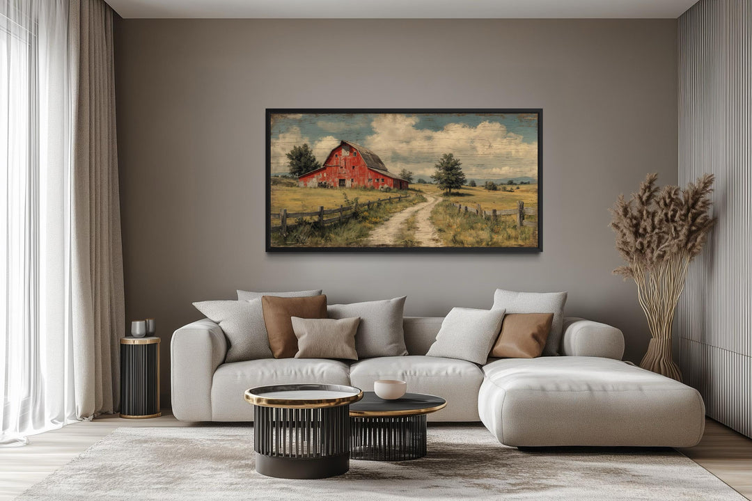 Large horizontal canvas print of a rustic red barn landscape in a modern farmhouse living room.