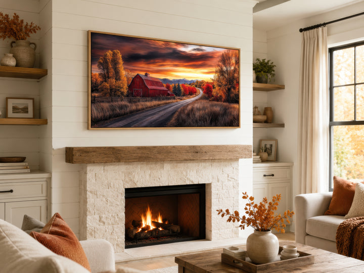 Framed red barn wall art above a fireplace in a rustic farmhouse living room with autumn decor.