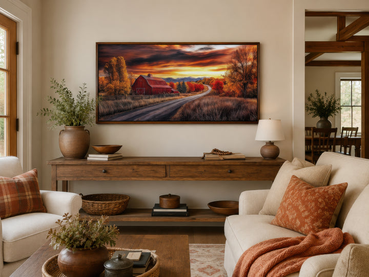 Framed red barn wall art in a rustic living room with autumn-themed decor and warm lighting.