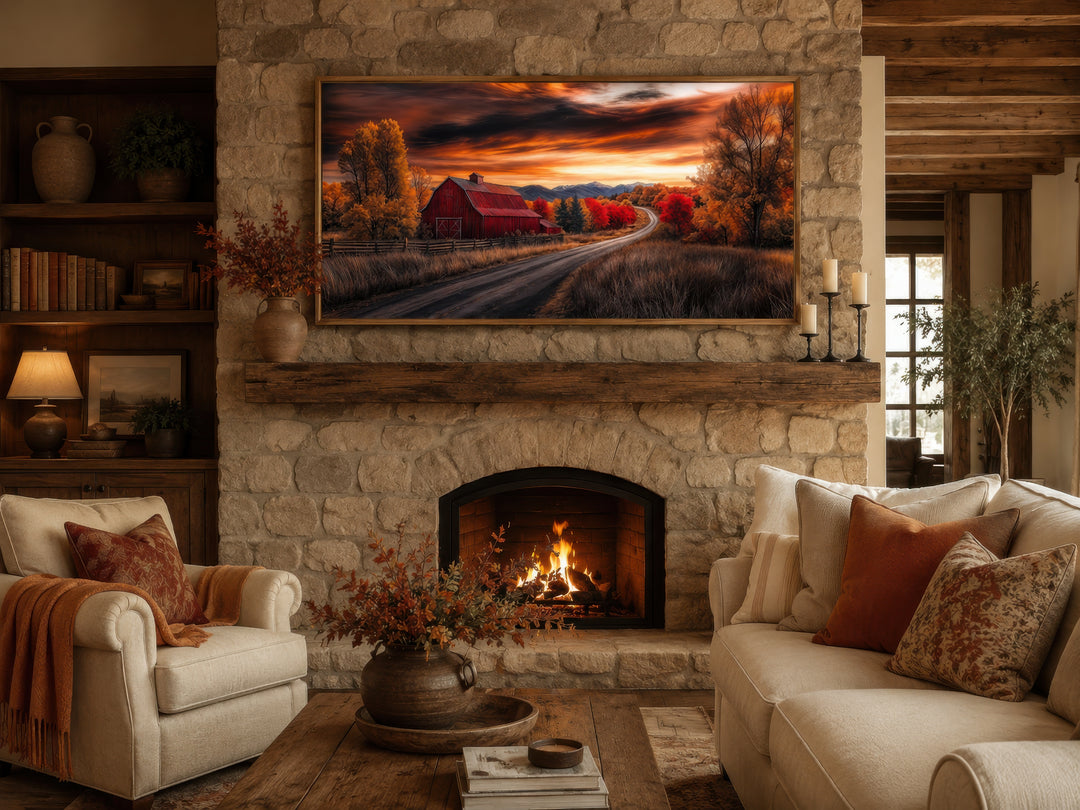 Framed red barn wall art above a stone fireplace in a cozy rustic living room with fall decor.