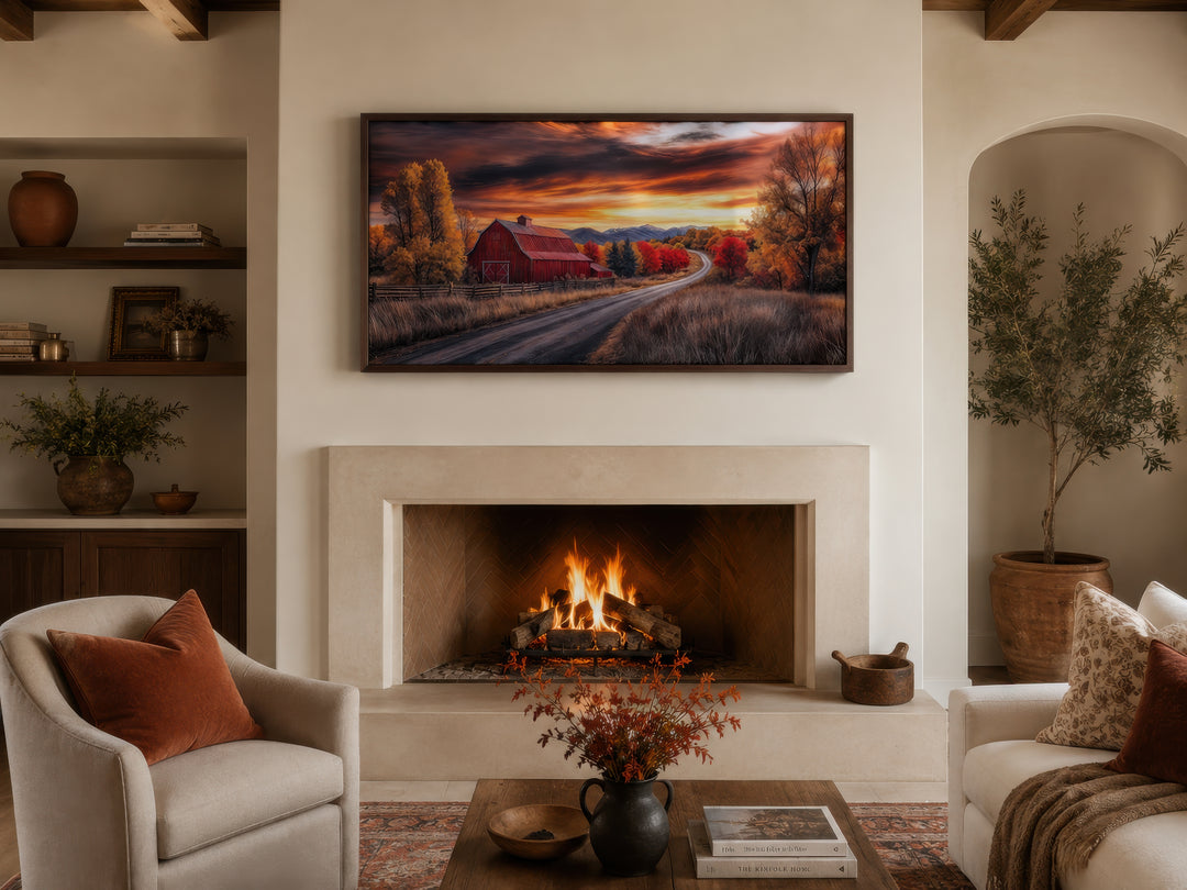 Framed red barn wall art above a fireplace in a cozy farmhouse living room with autumn decor.