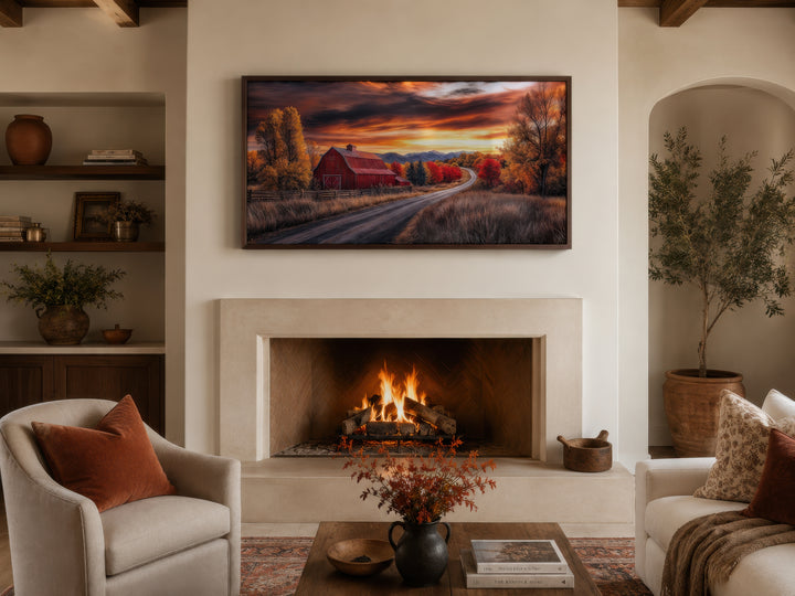 Framed red barn wall art above a fireplace in a cozy farmhouse living room with autumn decor.