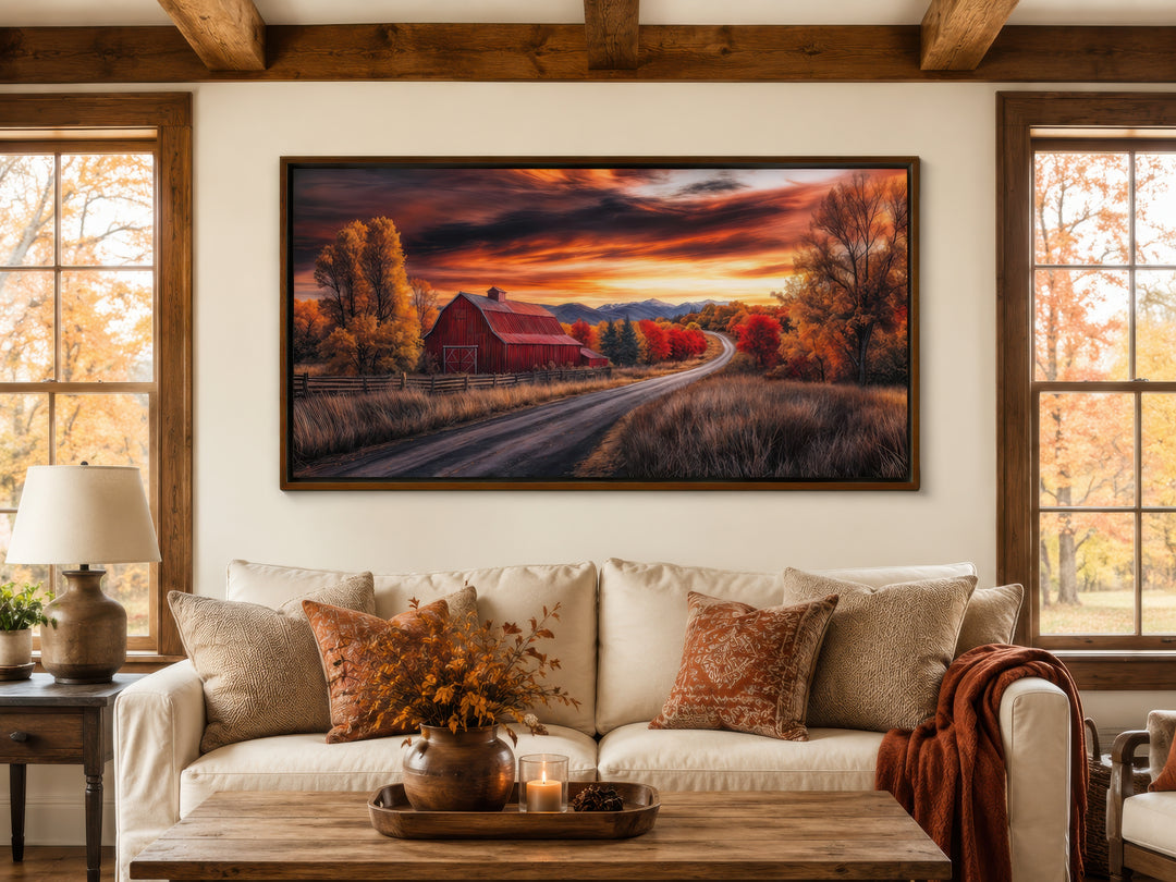 Framed red barn wall art in a rustic living room with fall-themed decor and a cozy white sofa.