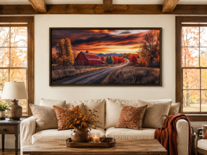 Framed red barn wall art in a rustic living room with fall-themed decor and a cozy white sofa.