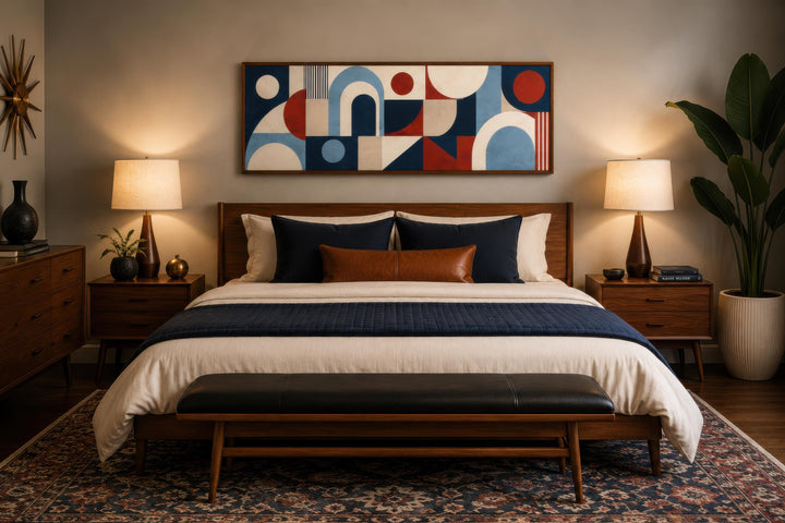 Long narrow Bauhaus wall art with red, blue, and cream geometric shapes above a mid-century bed.
