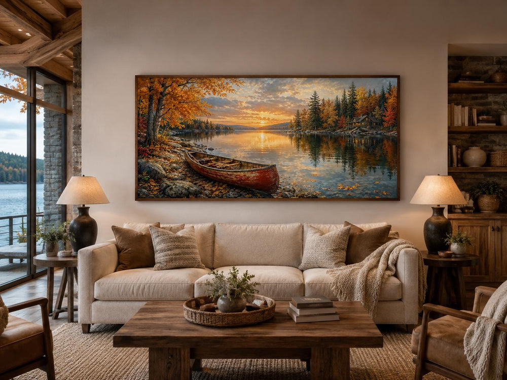 Red canoe on an autumn lake shore canvas wall art displayed above a sofa in a rustic living room.