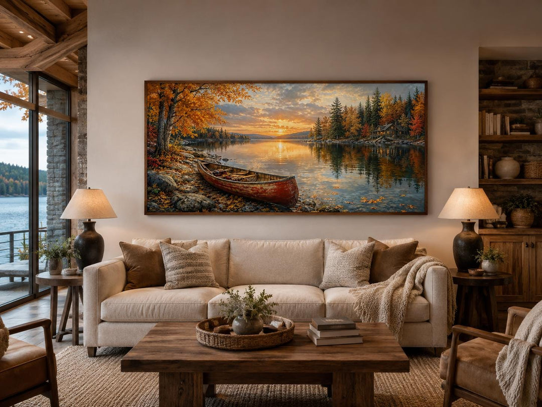 Red canoe on an autumn lake shore canvas wall art displayed above a sofa in a rustic living room.