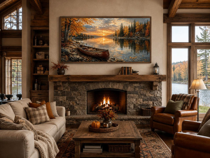 Red canoe on an autumn lake shore canvas wall art hanging above a rustic stone fireplace.