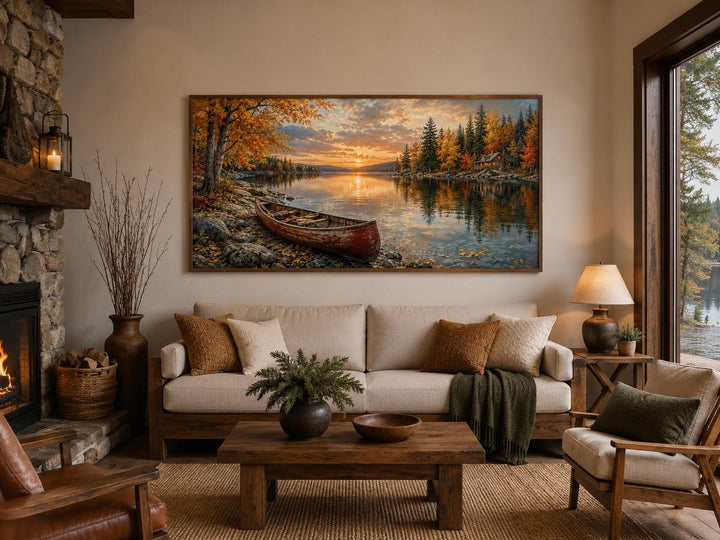 Red canoe on an autumn lake shore canvas wall art displayed above a sofa in a rustic living room.