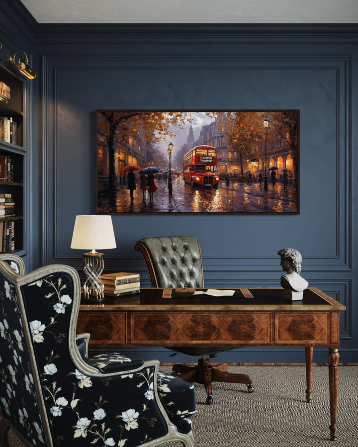 Framed canvas art of a red double decker bus in rainy London above a classic wooden office desk.