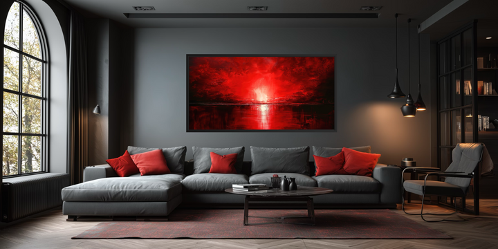 A large framed canvas wall art of a red ocean sunset hangs in a modern, dark-toned living room.