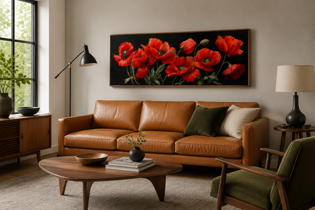 Long horizontal framed canvas wall art featuring red poppies on a black background above a sofa.