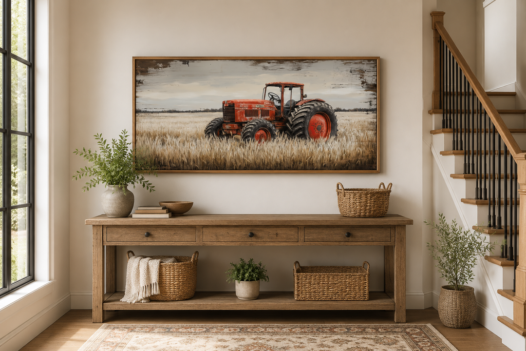 Framed rustic wall art of a red tractor in a golden wheat field above a wooden console table.