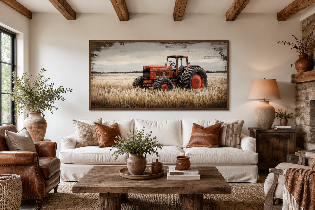 Red tractor in a wheat field rustic farmhouse wall art framed above a white sofa in a living room.