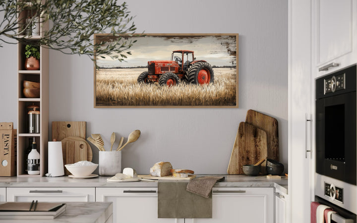 Framed rustic wall art of a red vintage tractor in a golden wheat field in a kitchen setting.