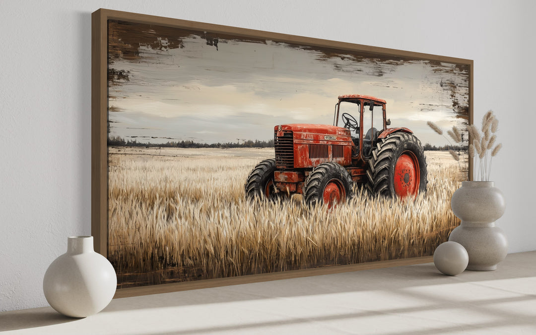 Framed canvas art of a vintage red tractor in a golden wheat field with a rustic farmhouse style.
