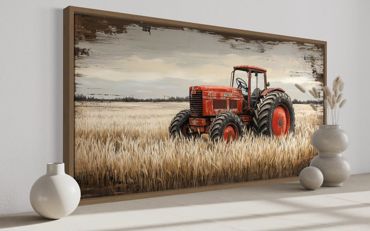 Framed canvas art of a vintage red tractor in a golden wheat field with a rustic farmhouse style.