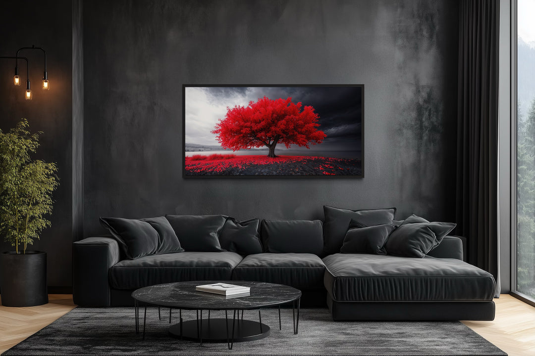 Framed canvas print of a vibrant red tree against a black and white landscape in a modern room.