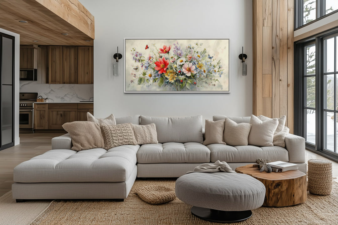 Red wildflowers bouquet watercolor botanical framed canvas wall art above a modern sectional sofa.