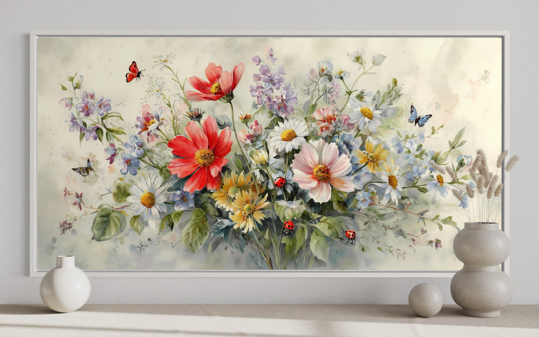 Watercolor framed canvas wall art of red wildflowers, daisies, ladybugs, and butterflies.