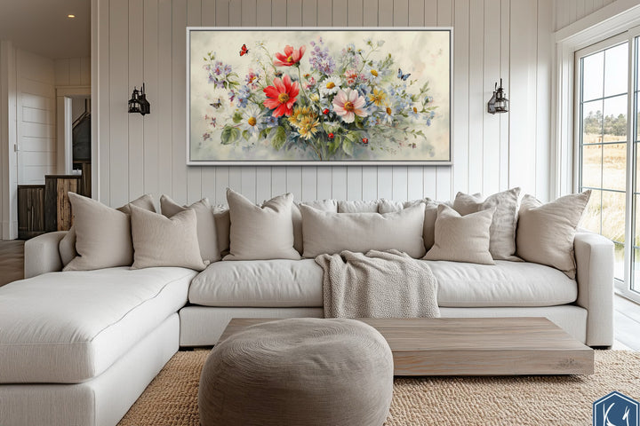 Red wildflowers bouquet watercolor botanical framed canvas wall art above a neutral sectional sofa.