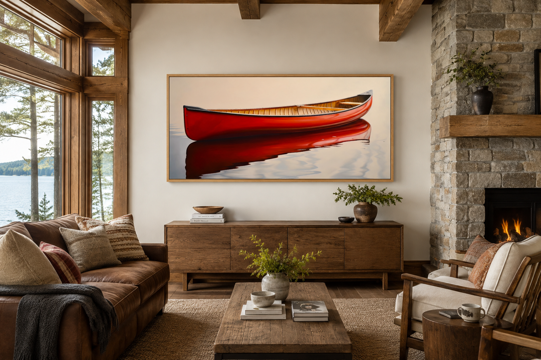 Framed canvas print of a red canoe on calm water, styled as rustic cabin wall decor above a console.