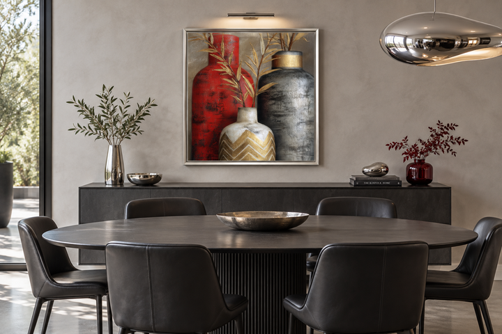 Modern wall art of red, gold, and silver vases above a dining table with black leather chairs.
