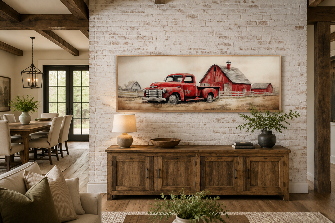 Red truck and barn painting on wood framed canvas wall art above a rustic wooden sideboard.