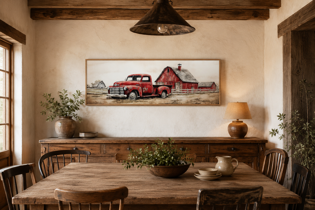 Red truck and barn painting on wood framed canvas wall art in a rustic dining room.