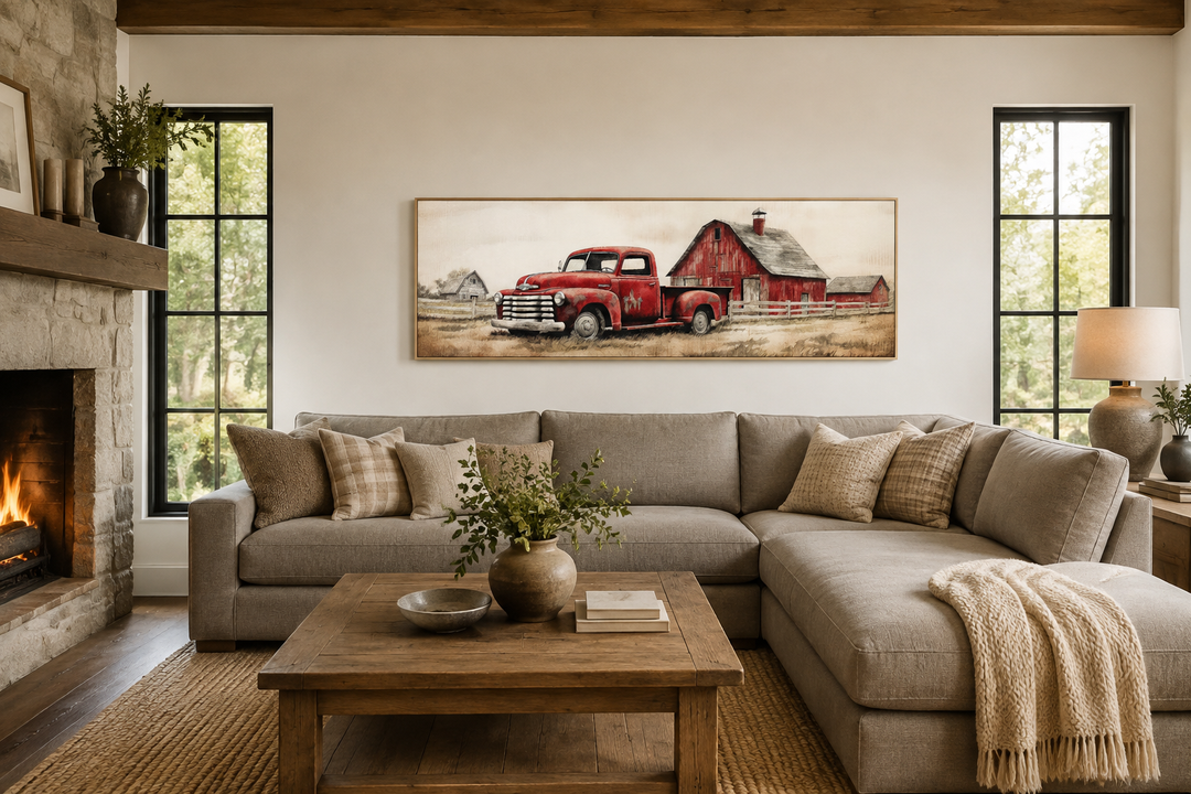 Red truck and barn painting on wood framed canvas wall art above a neutral sectional sofa.