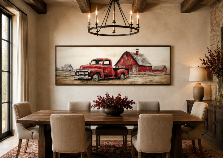 Red truck and barn painting on wood framed canvas wall art above a rustic dining table.