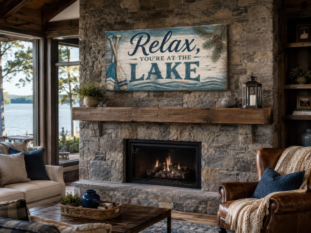 Rustic 'Relax, You're At The Lake' canvas sign mounted above a stone fireplace in a lake house.