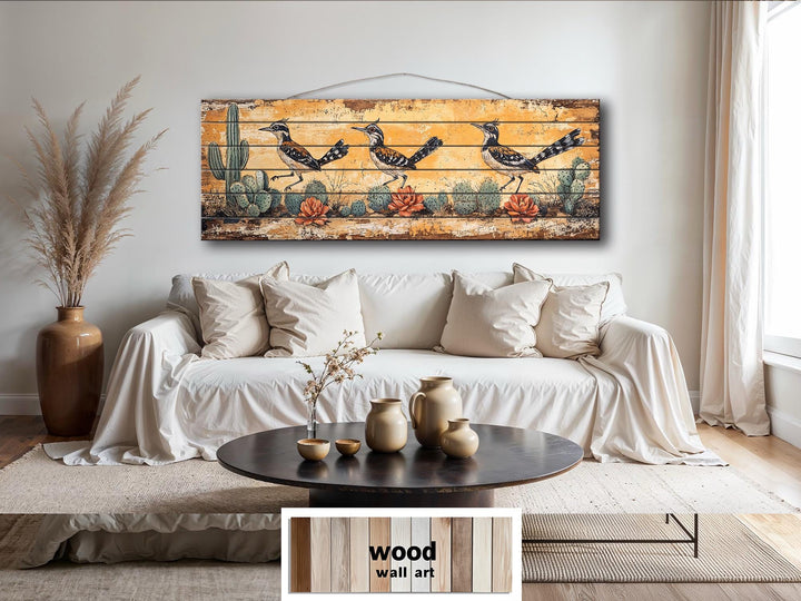 Horizontal wood wall art featuring three roadrunners in a distressed desert landscape with cacti.