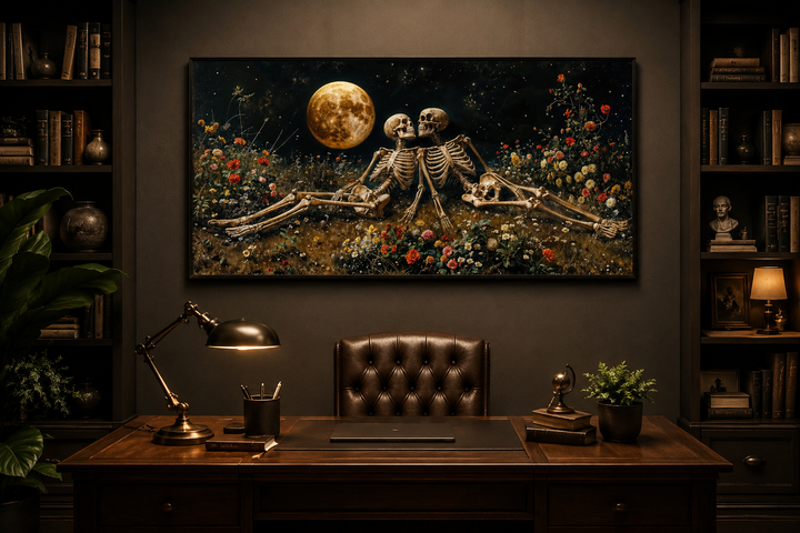 Gothic wall art of two skeletons in a flower meadow under a full moon, hung above a dark wood desk.