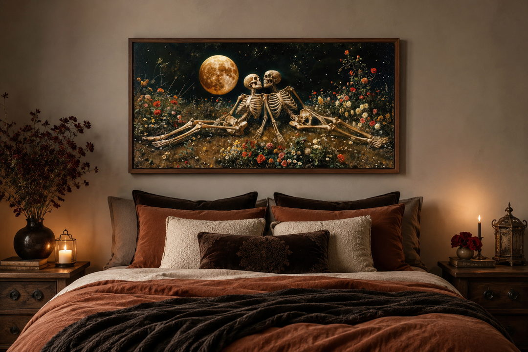 Framed gothic wall art of two skeletons in a flower meadow under a full moon above a bed.