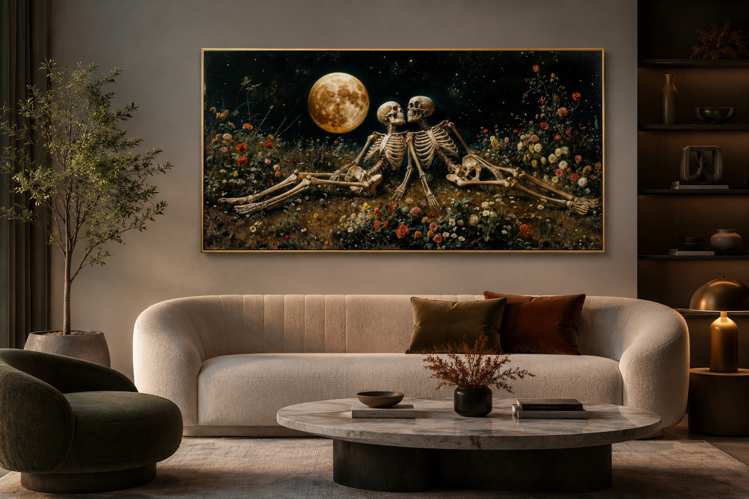 Romantic gothic wall art of two skeletons in a floral meadow under a full moon above a sofa.