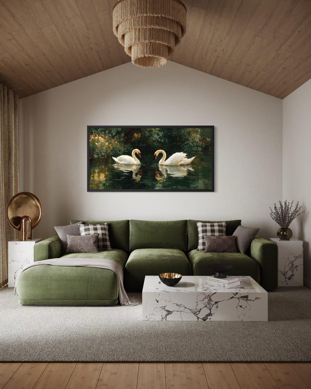 A horizontal canvas painting of two white swans on a dark lake hangs above a green velvet sofa.